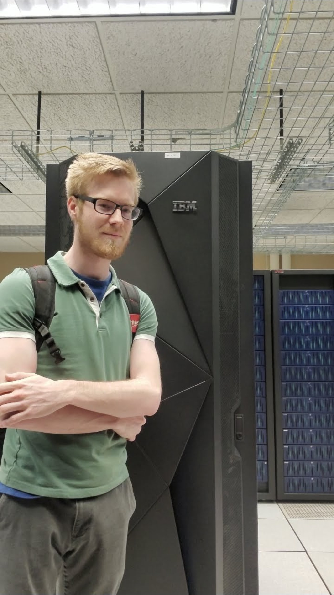 Luke Lavender beside an IBM rack in 2020 with the IBM logo readable